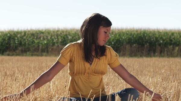 女孩坐在麦田在前面的玉米4股票的录像视频免费下载