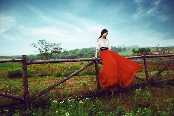 坐在马场围栏上的红裙新娘图片
