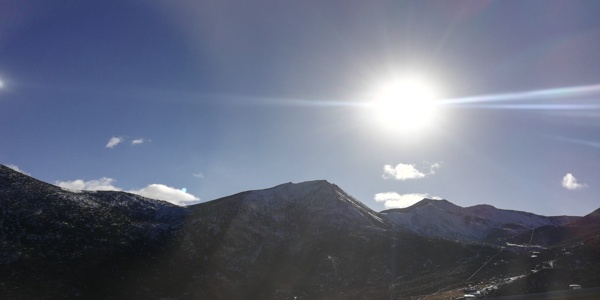 蓝天雪山太阳光晕风景图片