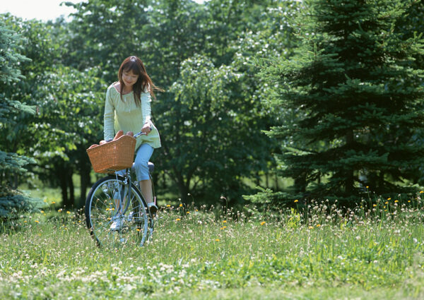 在草丛中骑单车的女人图片