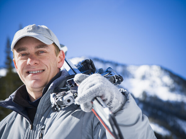 肩扛滑雪工具的男性图片