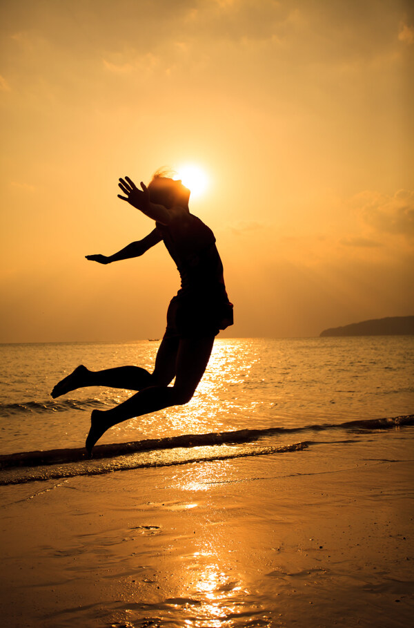 海边跳跃的女人剪影图片