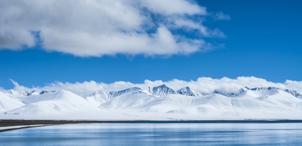 藍(lán)天白云下平靜湖泊與壯麗雪山