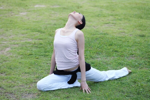 在草地上做瑜伽的运动少女图片图片