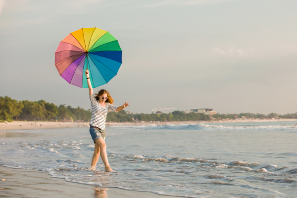 海滩打伞散步的美女图片