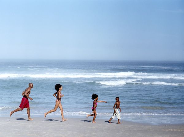 沙滩上的奔跑的外国家庭图片
