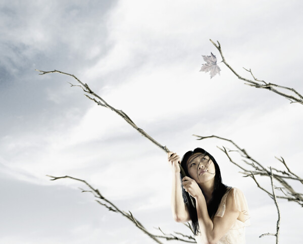 手把着树枝孤独的仰望天空的女孩图片