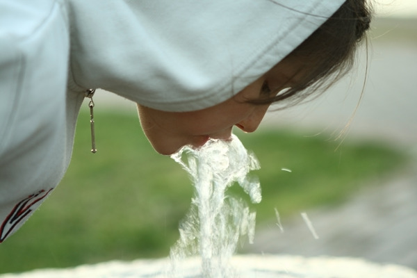 小女孩的饮用水从喷泉
