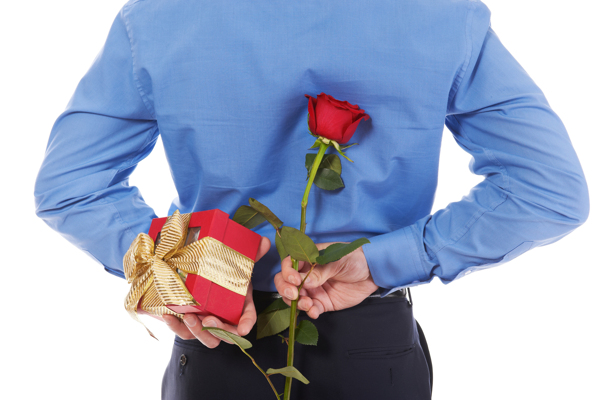把礼物与玫瑰花藏在身后的男人图片