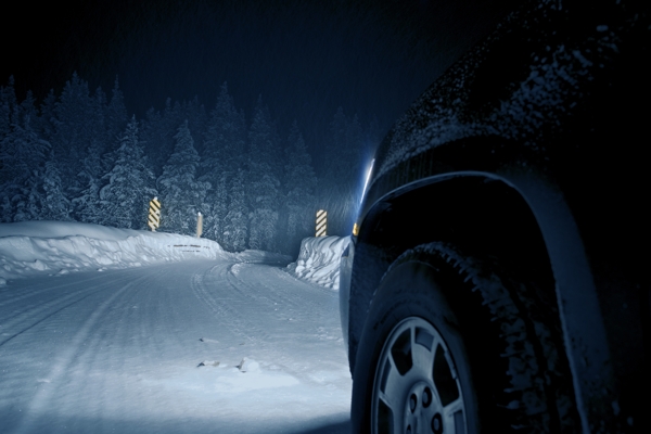 夜晚雪地里行驶的轿车图片