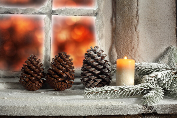 窗台上的松塔松枝和蜡烛图片