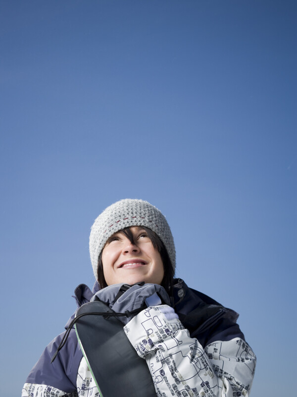 抱着滑雪板微笑的女性图片