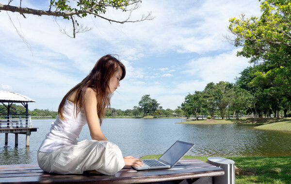 湖边玩电脑的女人图片